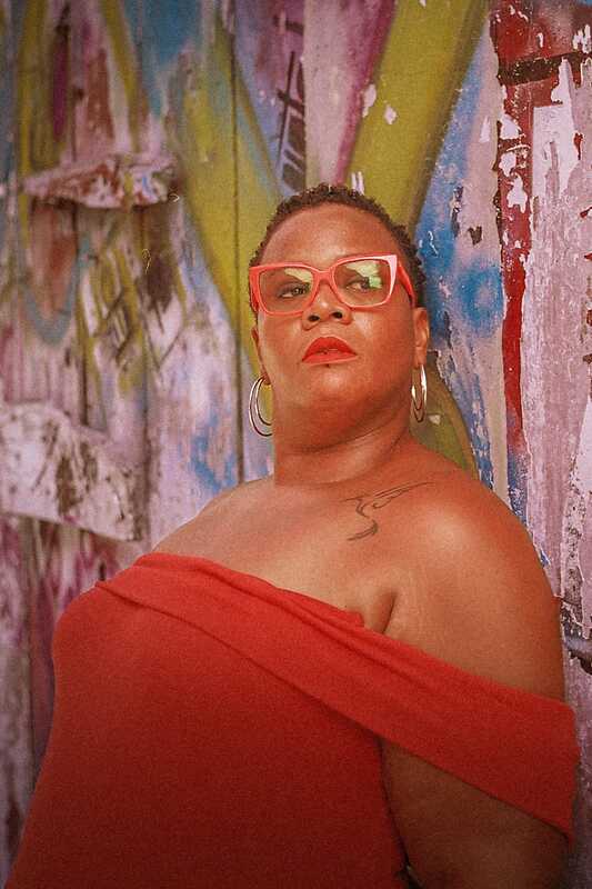 photo portrait de l'autrice madame.naiive avec sa signature lunettes et rouge à lèvres rouges.