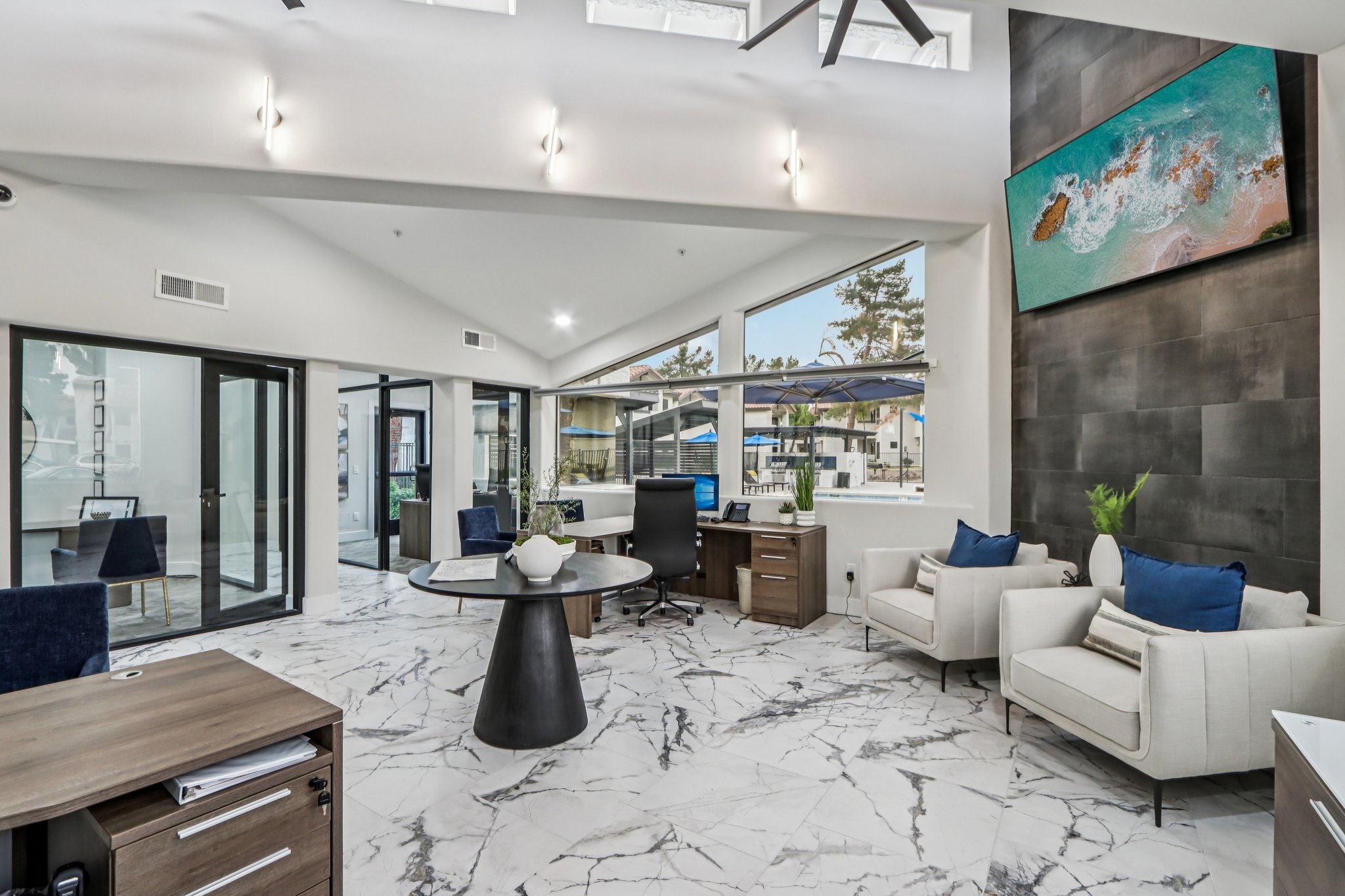 Leasing office lobby with chairs, tv, and desks