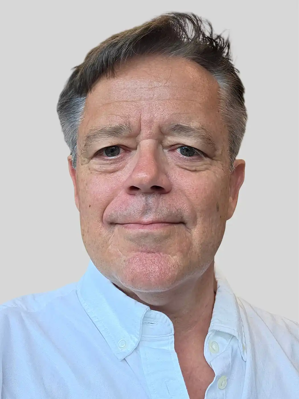 A headshot of a man smiling with brown hair wearing a white button-up shirt