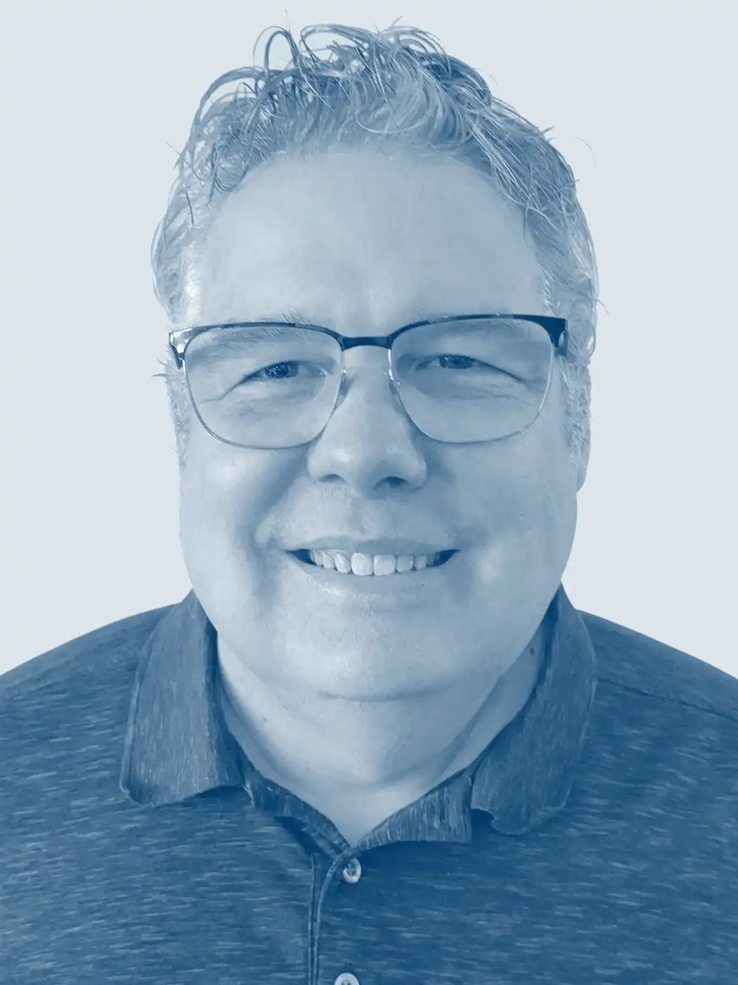A headshot of a man smiling with silver hair wearing glasses with a blue overlay effect on the image