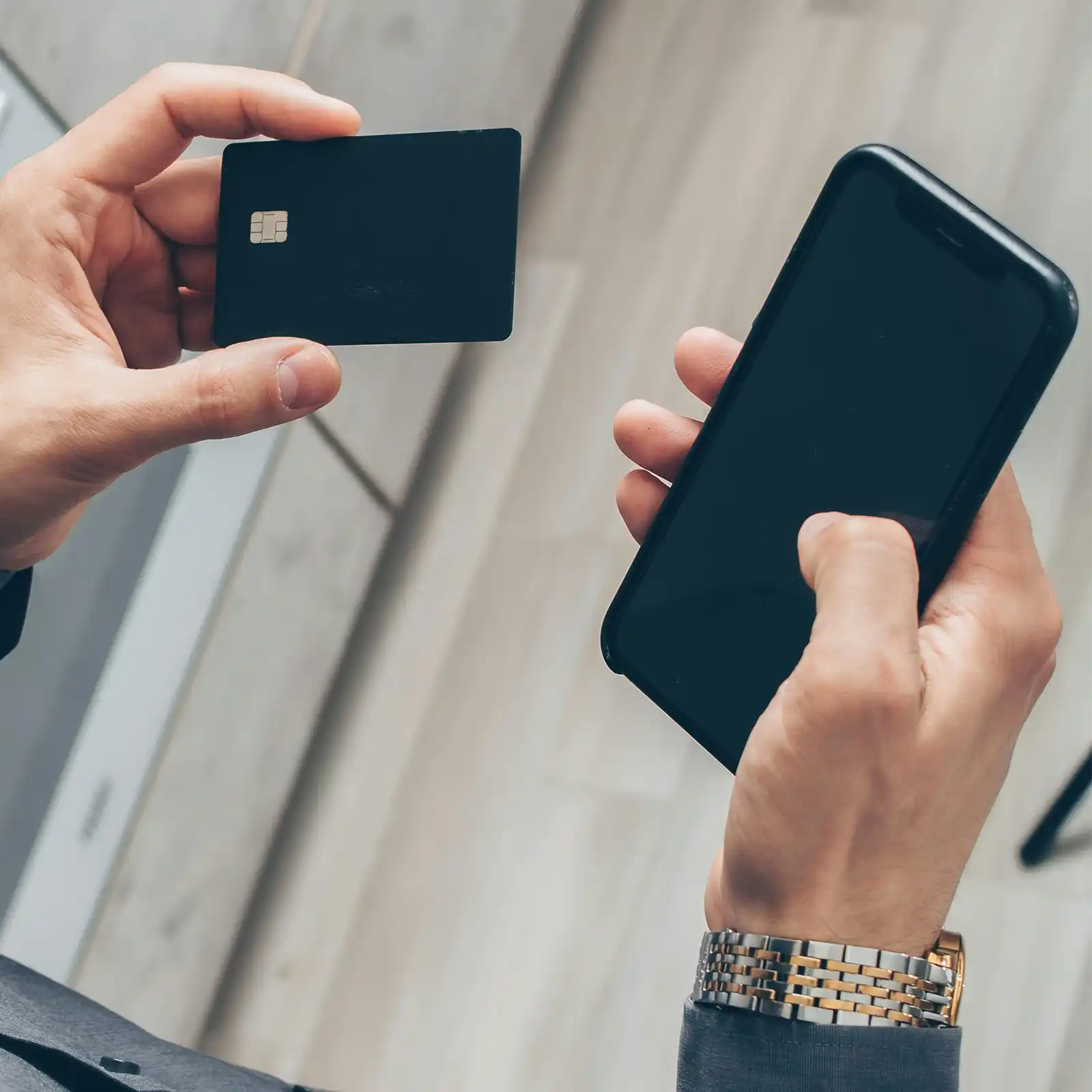 an overhead shot of a person holding a credit card and phone