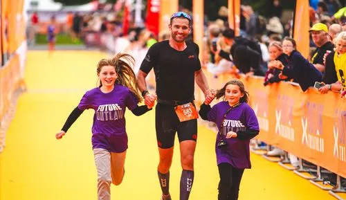 man holding hands with 2 children
