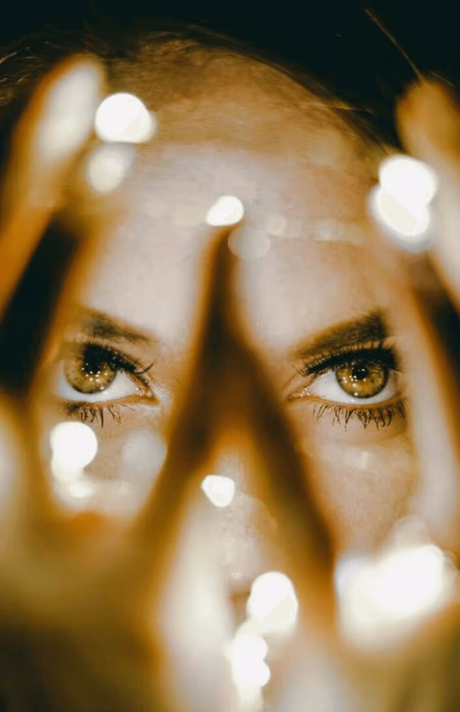 Close-up of a person’s eyes framed by warm lights beside text on Vonked belief in realness, psychological safety, and intentional transformation