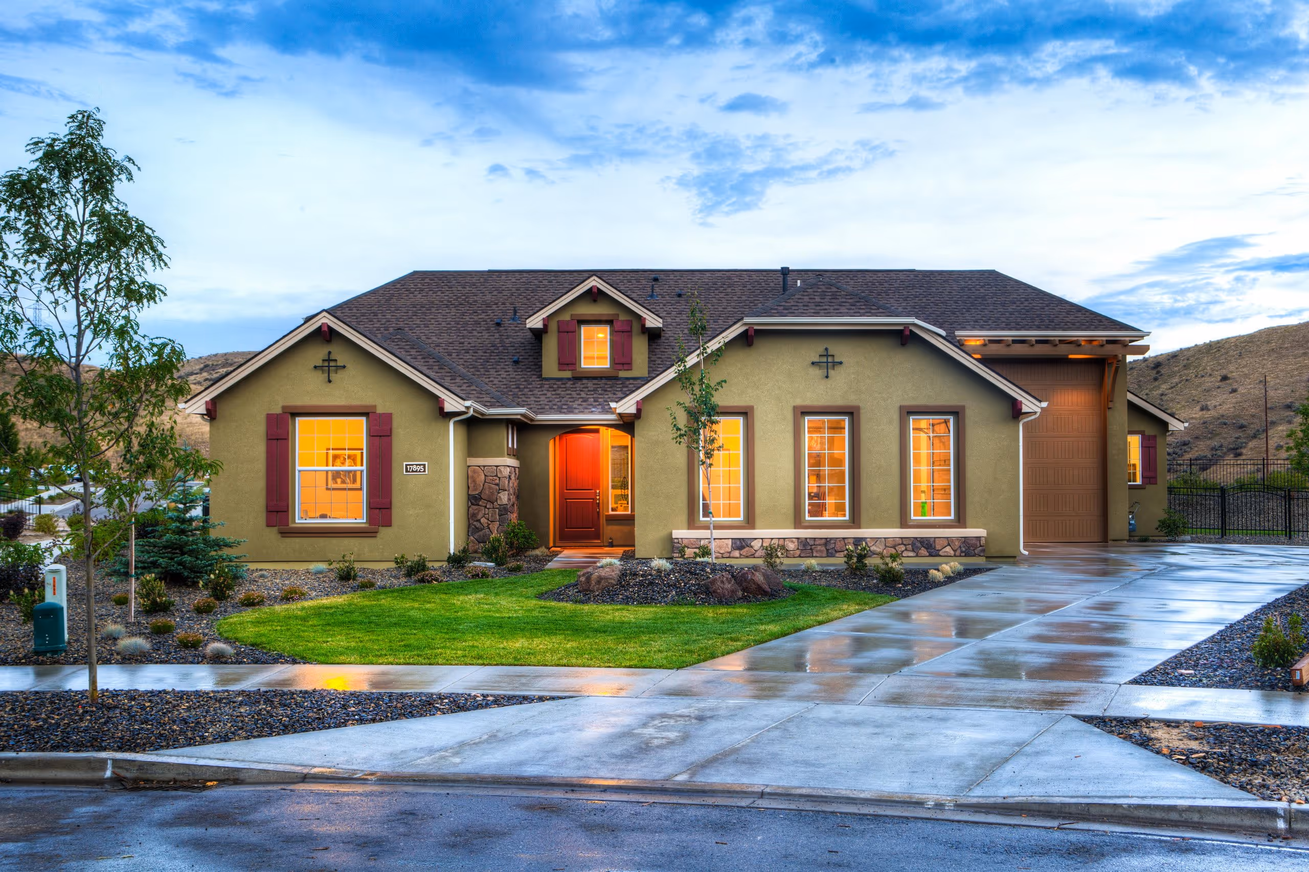 Beautiful home with painted green exterior, massive driveway, lights on in the house, beautiful aesthetic picture