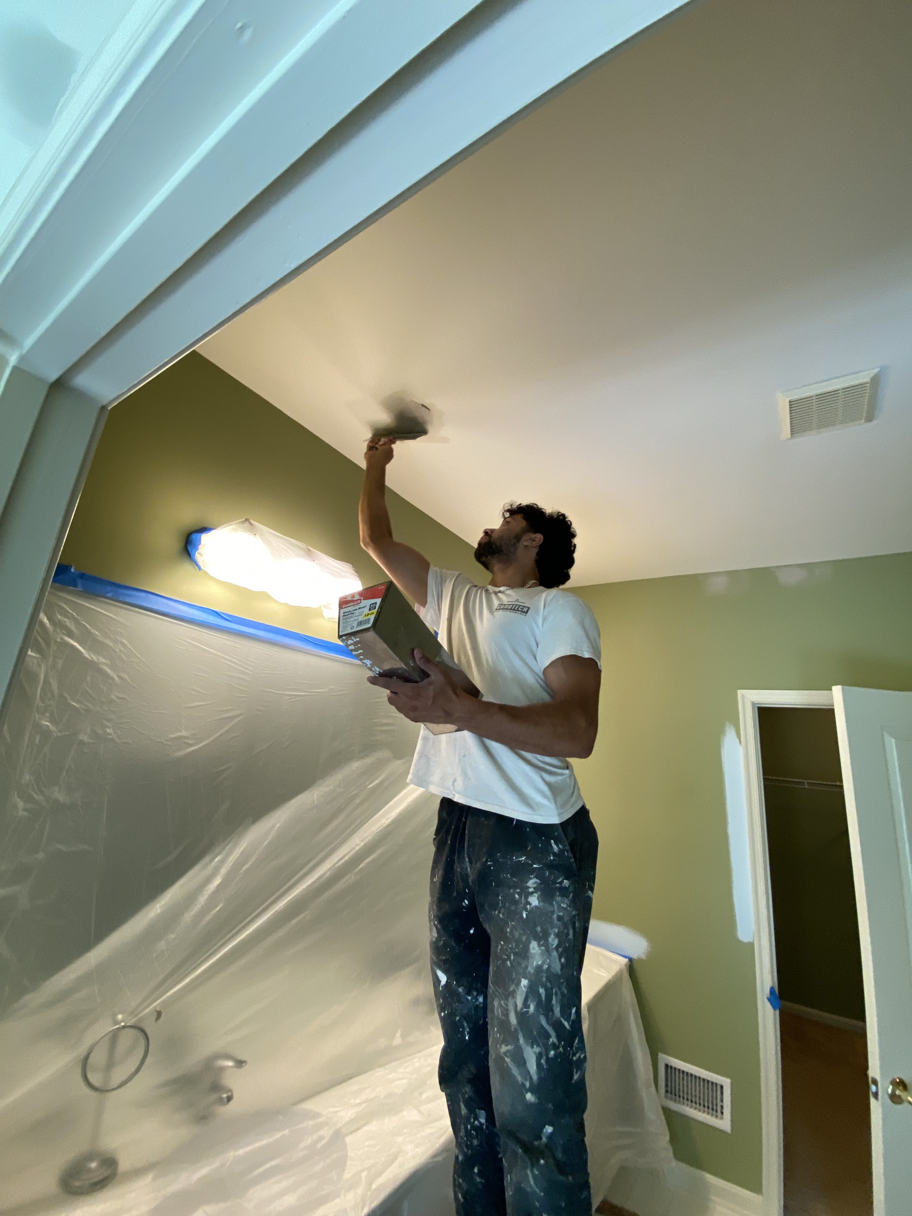 Khalid from PrimePro Painting & Power Washing Painting the inside of a home, on the roof.