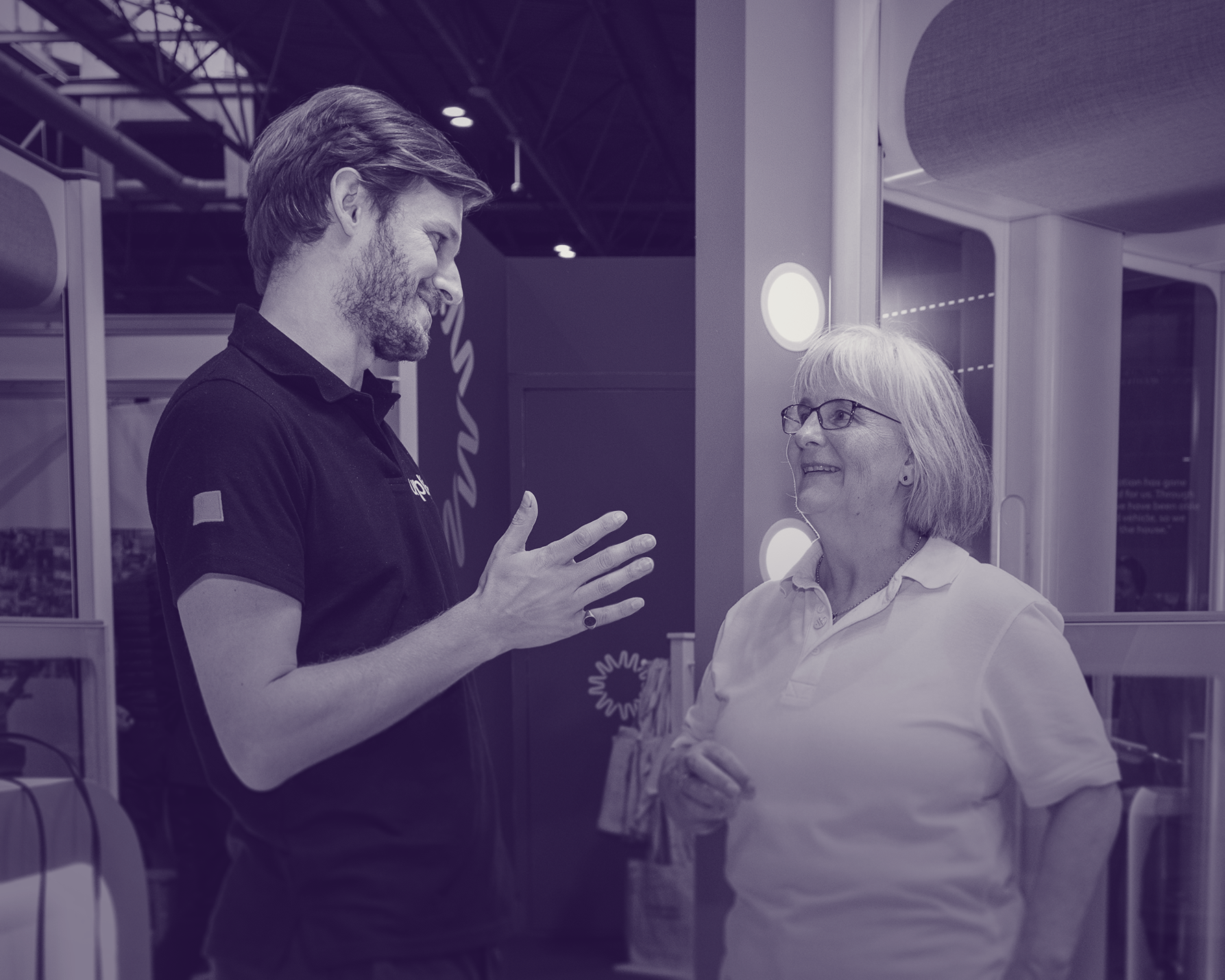 Kate talking with a man at a conference.