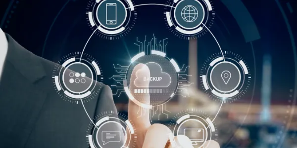 Person in suit interacting with a virtual interface showing a cloud backup icon surrounded by connected technology and communication icons.