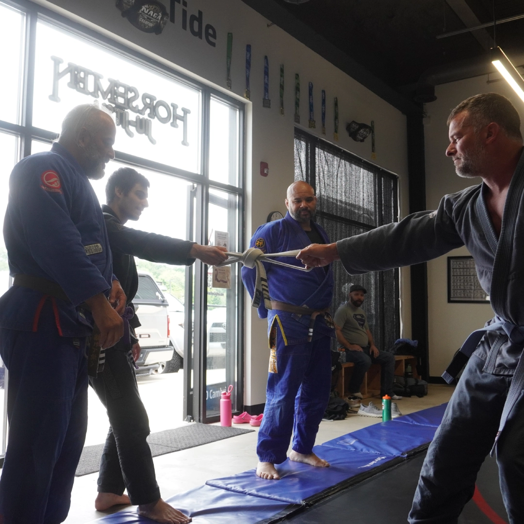 A man shakes hands with another man in a gym at Horsemen Brazilian Jiu Jitsu in New Freedom, PA.