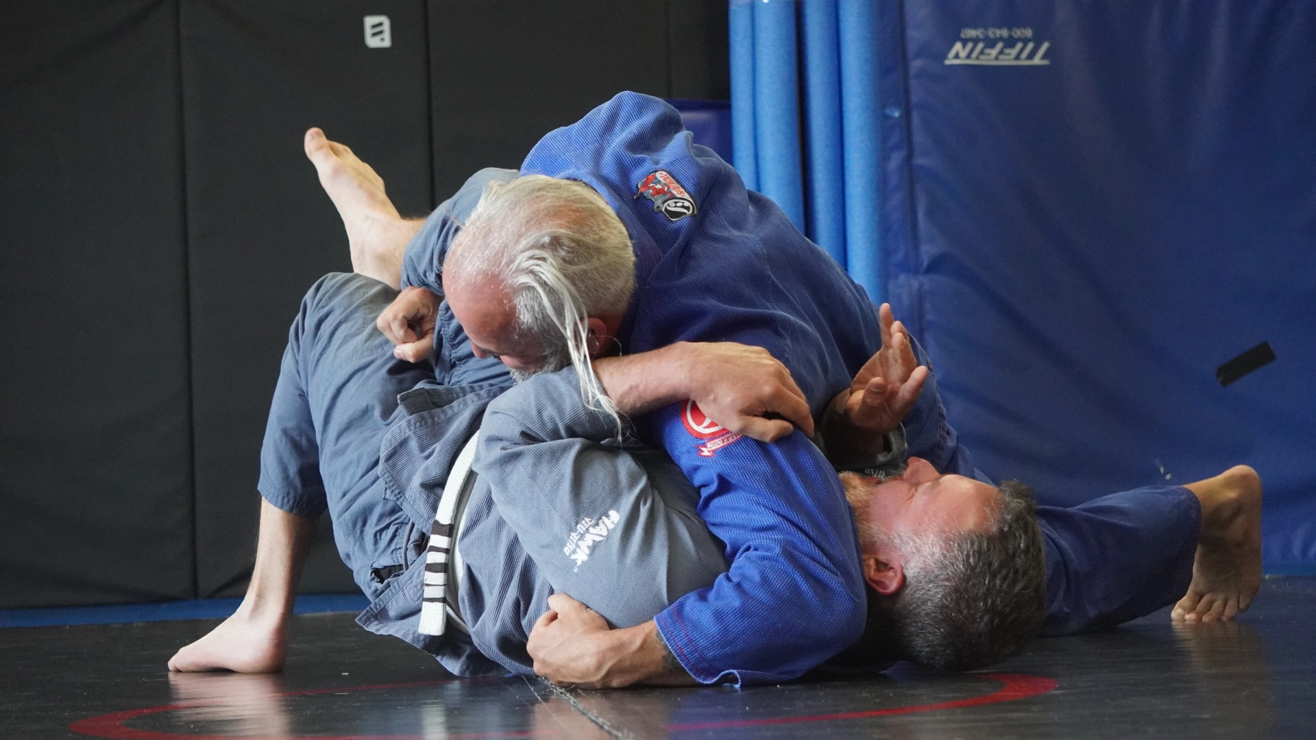 A man performs a Brazilian Jiu Jitsu move on the ground at Horsemen Brazilian Jiu Jitsu in New Freedom, PA.