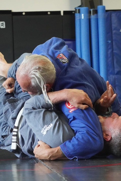 A man performs a Brazilian Jiu Jitsu move on the ground at Horsemen Brazilian Jiu Jitsu in New Freedom, PA.