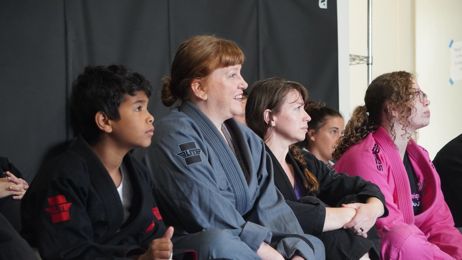 A group of people participating in fitness classes in a room with a black wall at Horsemen Brazilian Jiu Jitsu, New Freedom, PA.