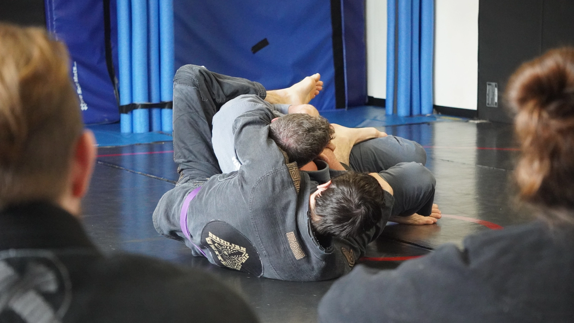 A man performs a Brazilian Jiu Jitsu move on the ground at Horsemen Brazilian Jiu Jitsu in New Freedom, PA.
