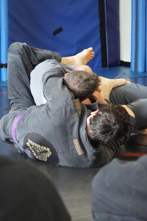 A man performs a Brazilian Jiu Jitsu move on the ground at Horsemen Brazilian Jiu Jitsu in New Freedom, PA.