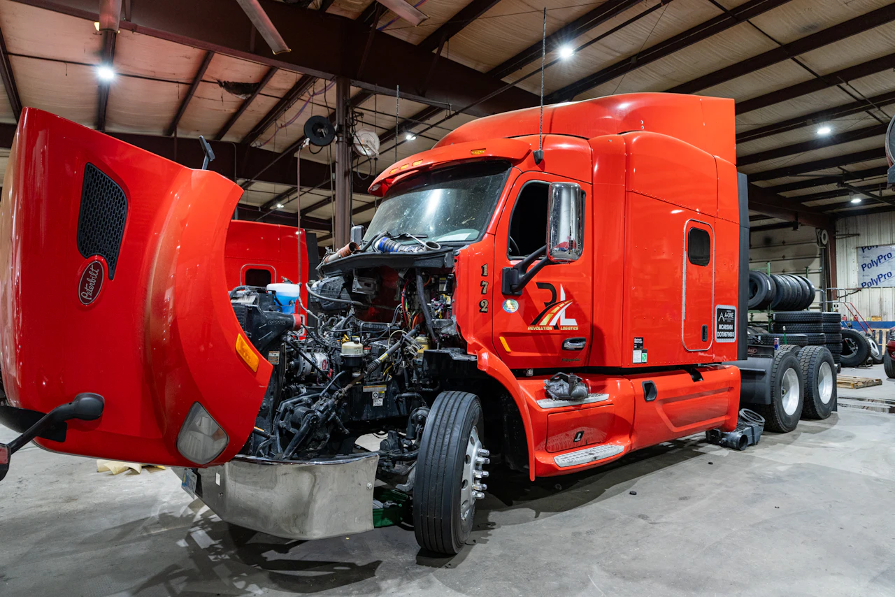 red semi truck with hood up for preventive maintenance 