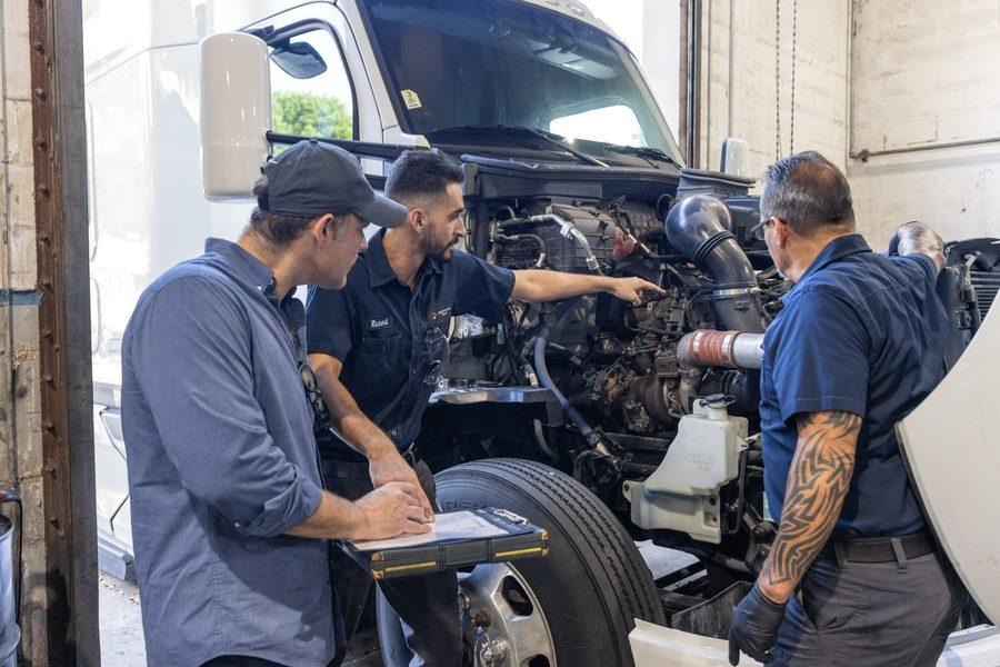 NH Repairs team reviewing open engine with client at Pompano Beach shop