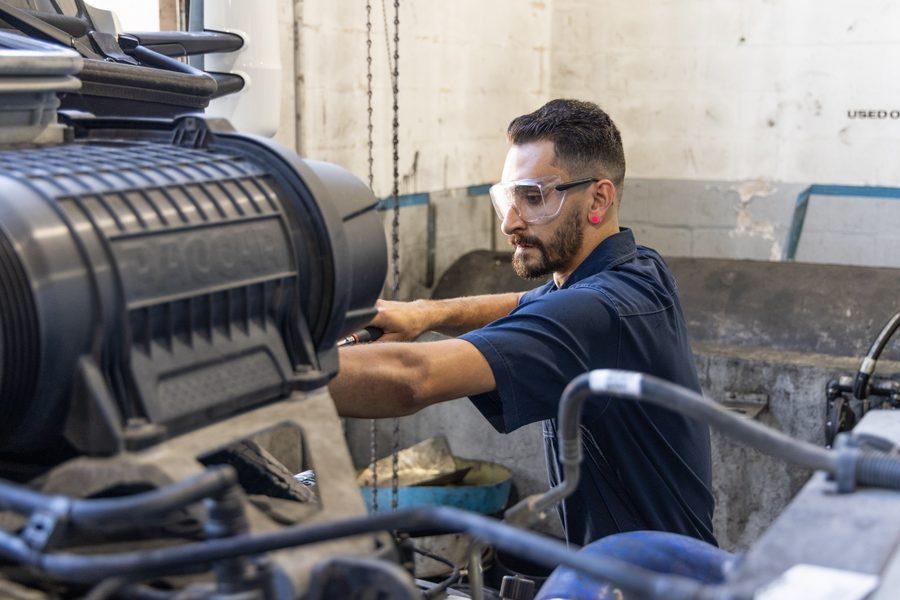 NH Repairs mechanic working on diesel engine components in Pompano Beach shop