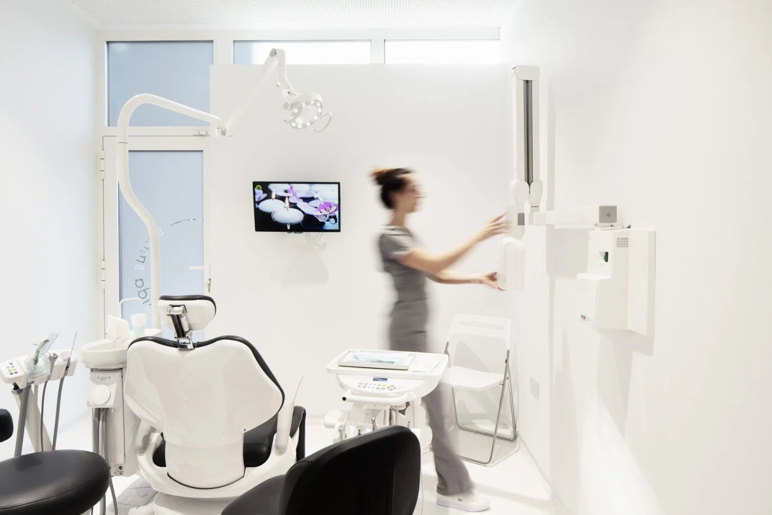 Smiling patient holding a clear Invisalign aligner