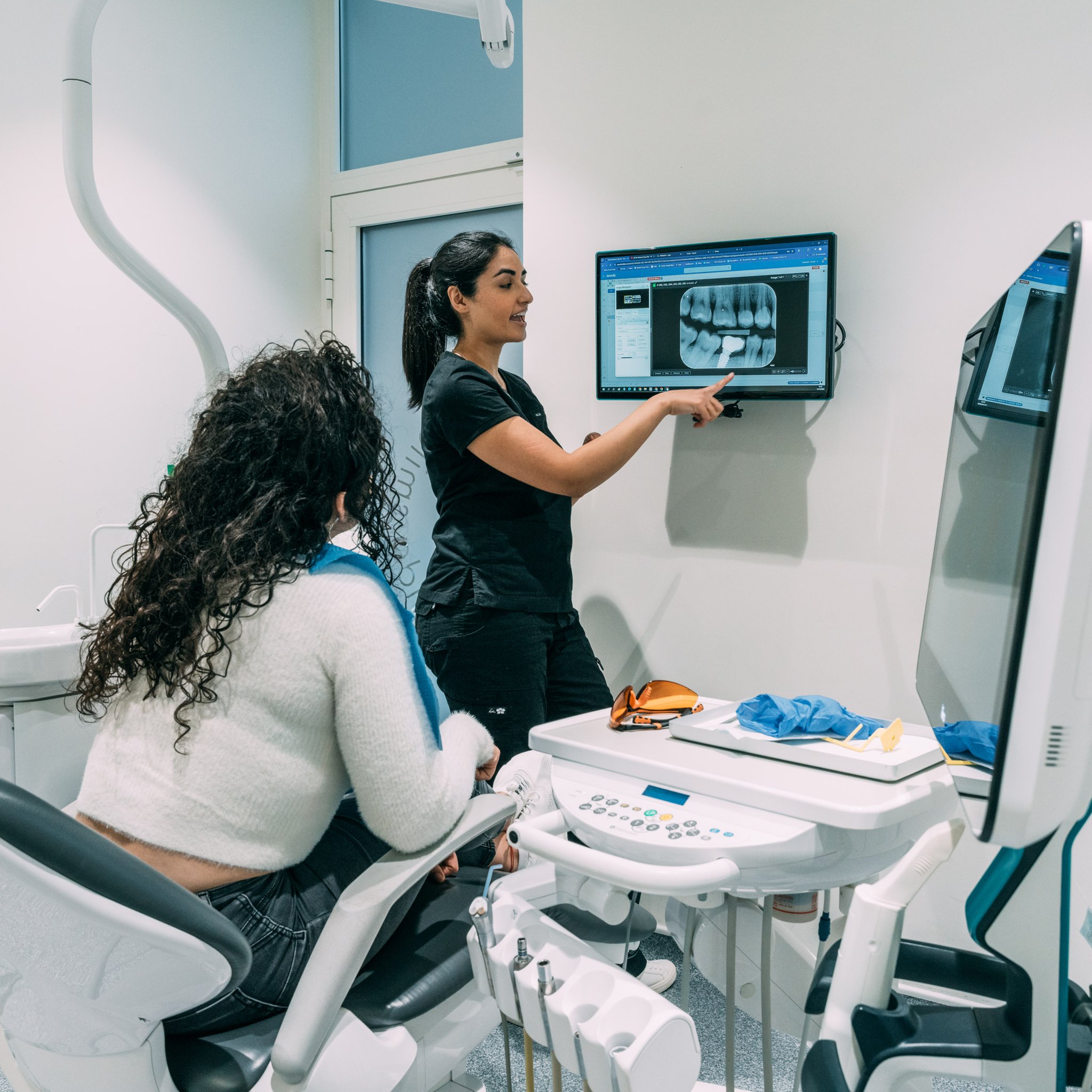 Dentist discussing an implant x-ray with a seated patient