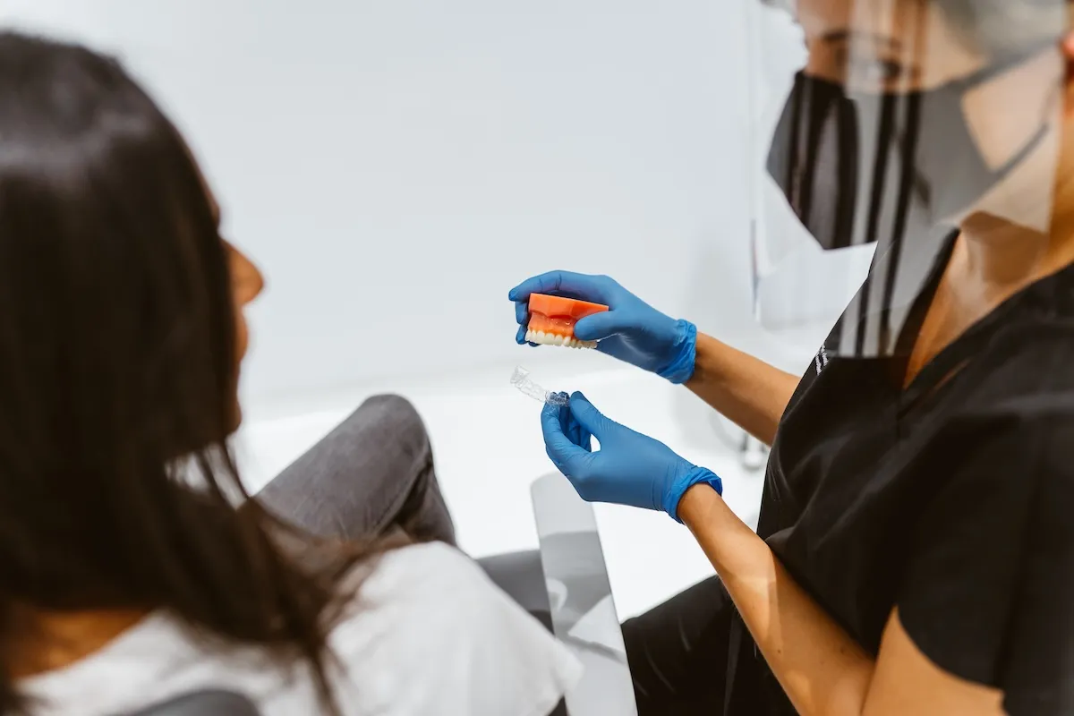 Dentist examining a patient's teeth in the dental chair at Maida Smiles