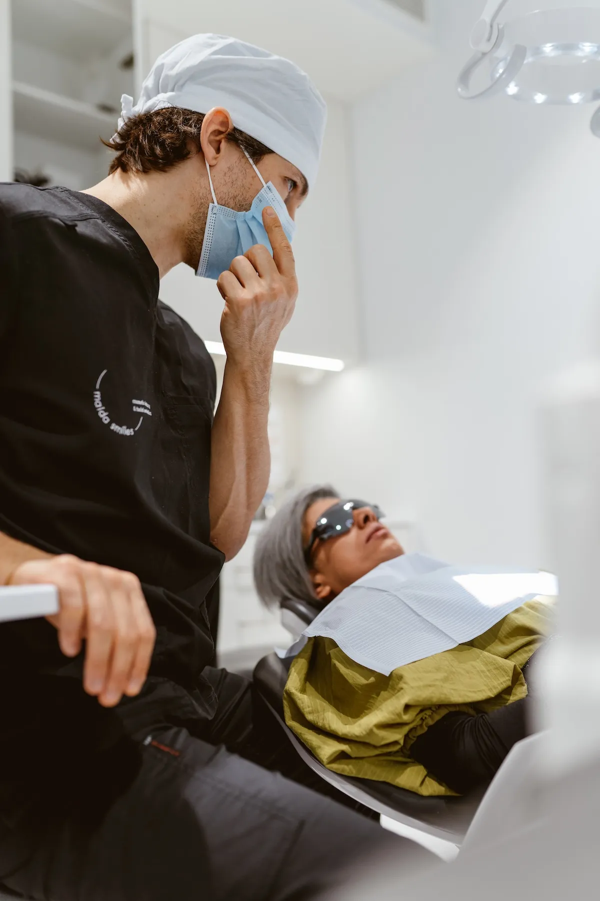 Dentist examining a patient's teeth in the dental chair at Maida Smiles