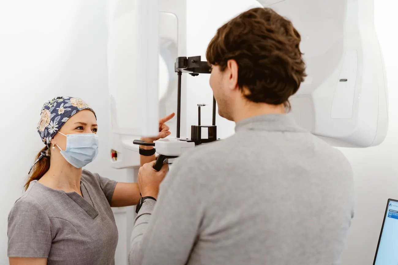Dentist examining a patient's teeth in the dental chair at Maida Smiles