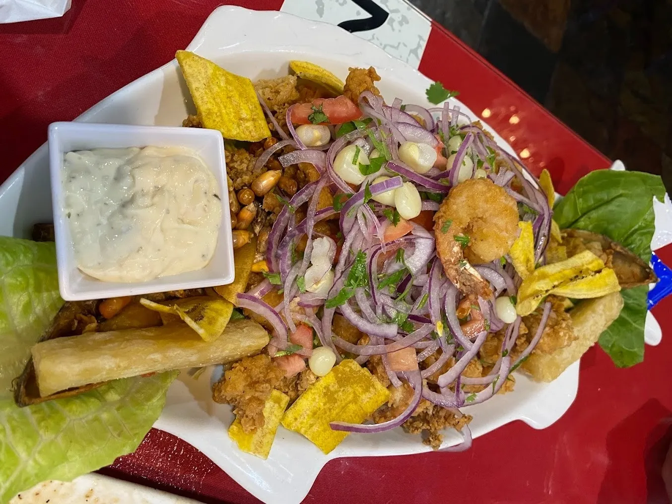 A plate of food featuring a side of crispy chips and creamy dip.