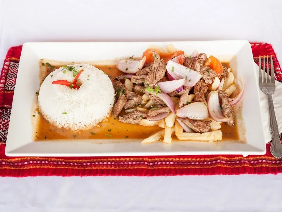 A plate filled with rice, tender meat, and colorful vegetables arranged appetizingly.