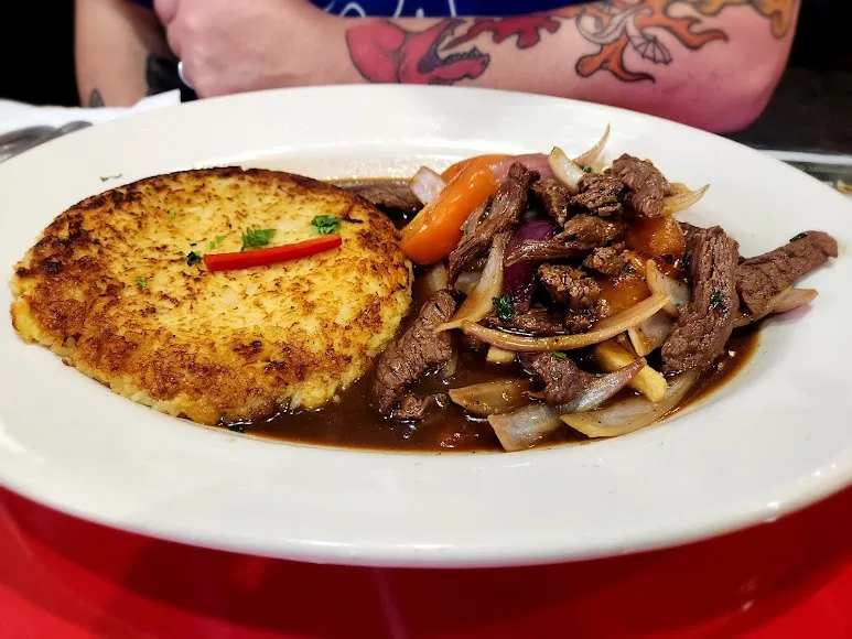 A plate featuring a savory meat dish alongside a creamy potato dish, beautifully presented for a delicious meal.