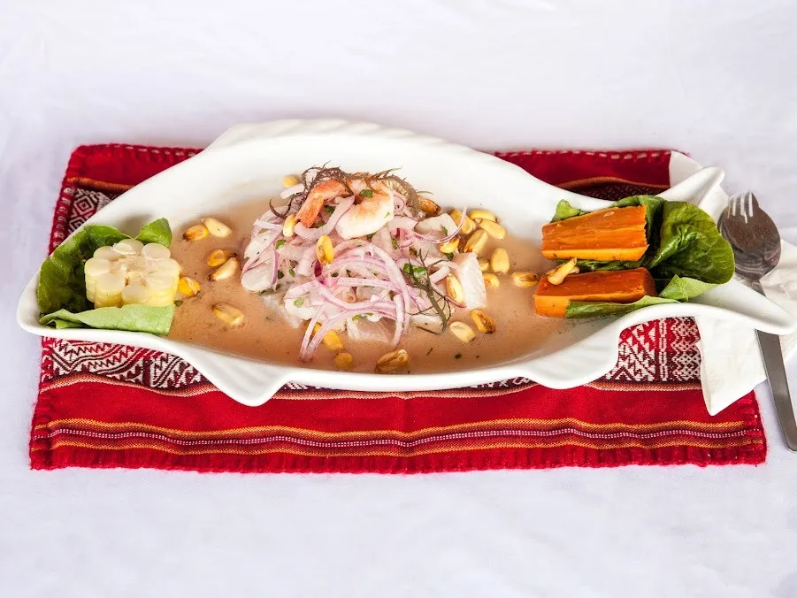 A dish of food on a plate, with a fork and knife placed beside it.