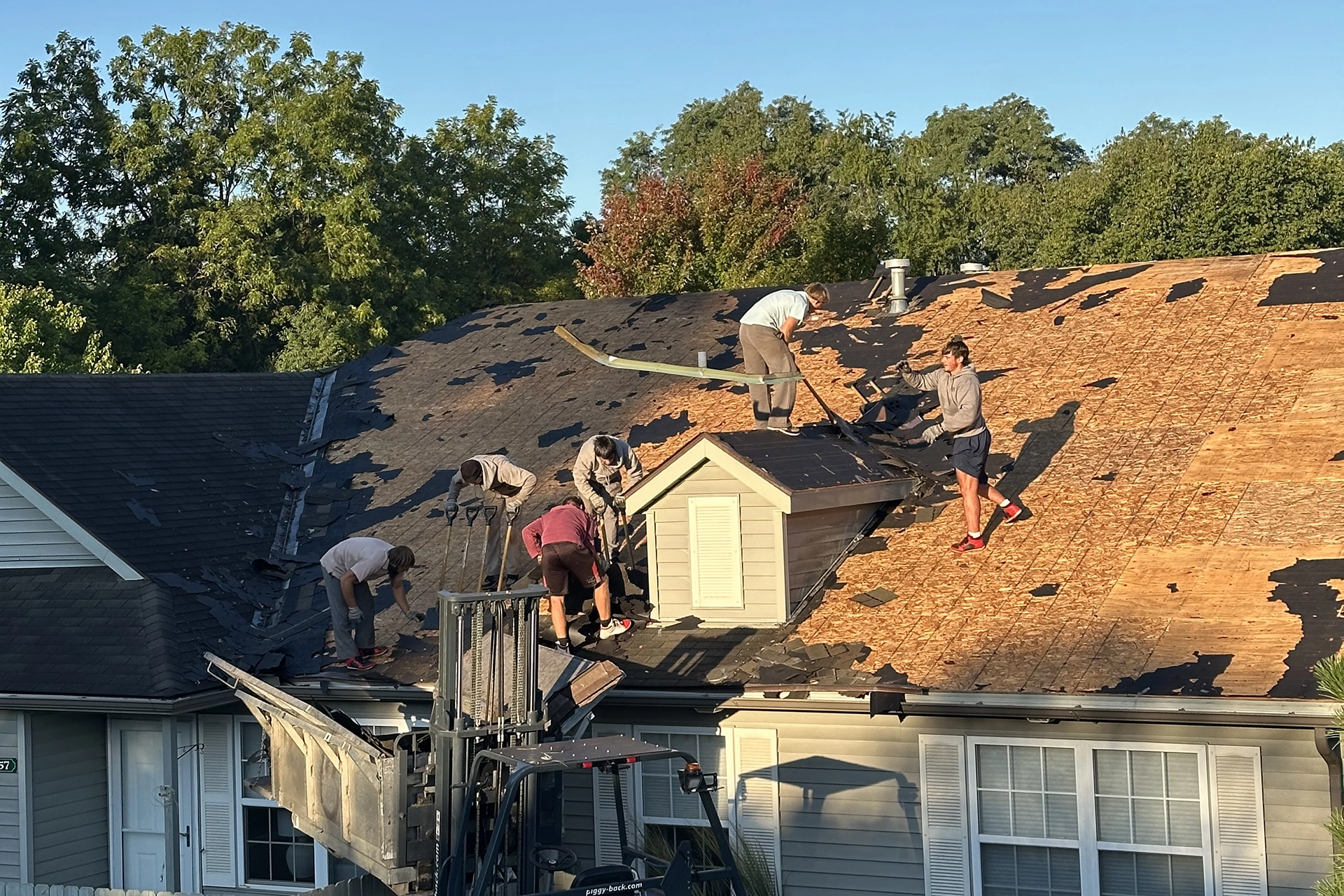 Roofers working on taking off the roof on a house