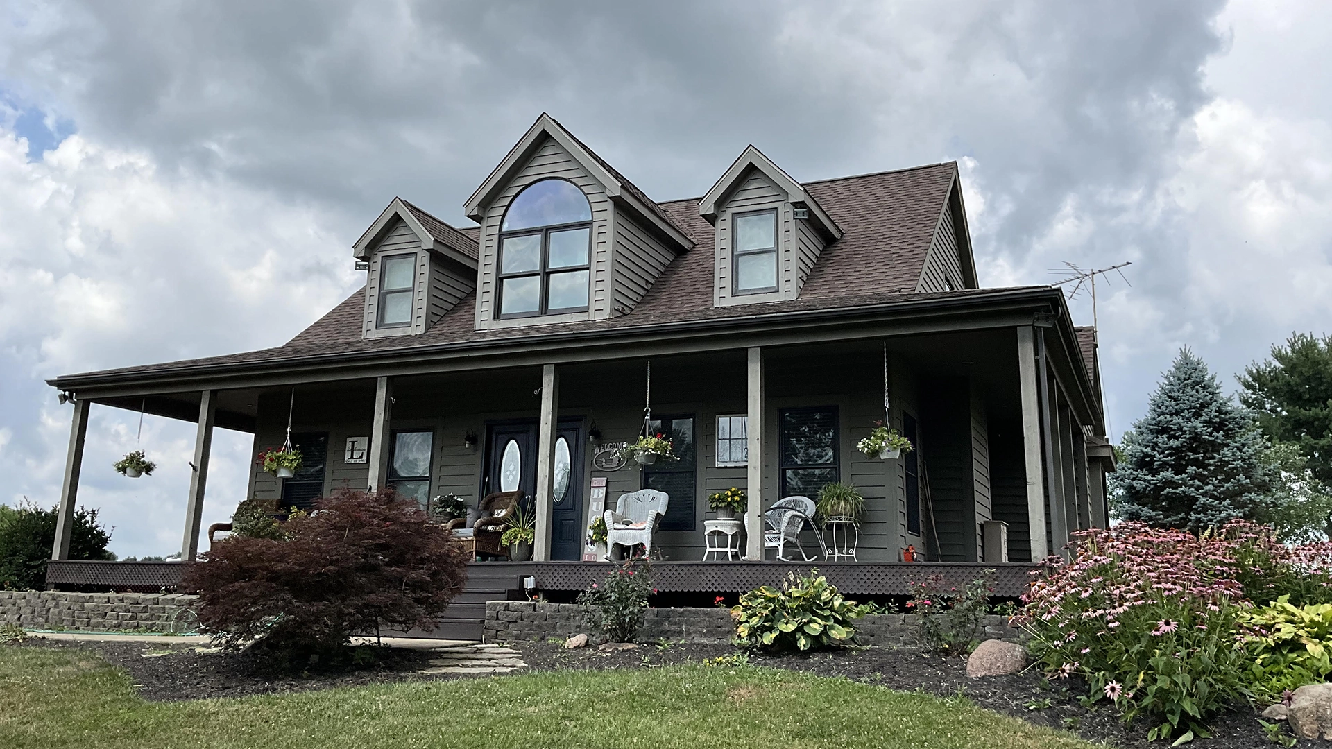 home with covered front porch shingled roof and front yard
