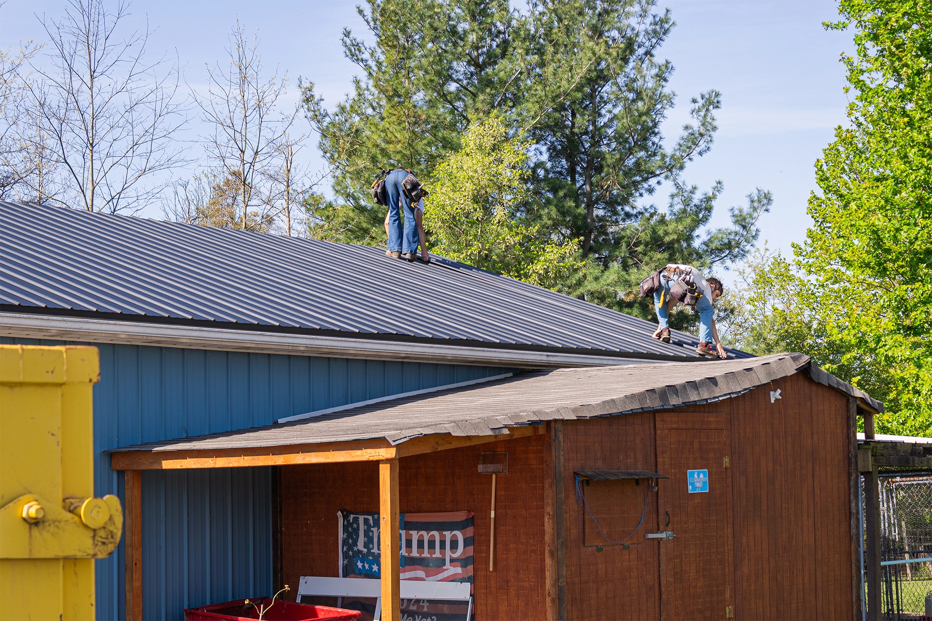 Roofers working on a black metal roof