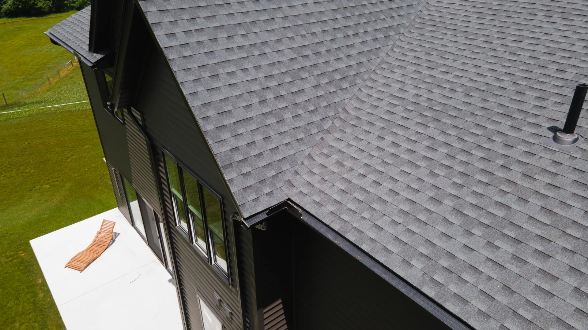 shingle roof on a multi-story home with black siding