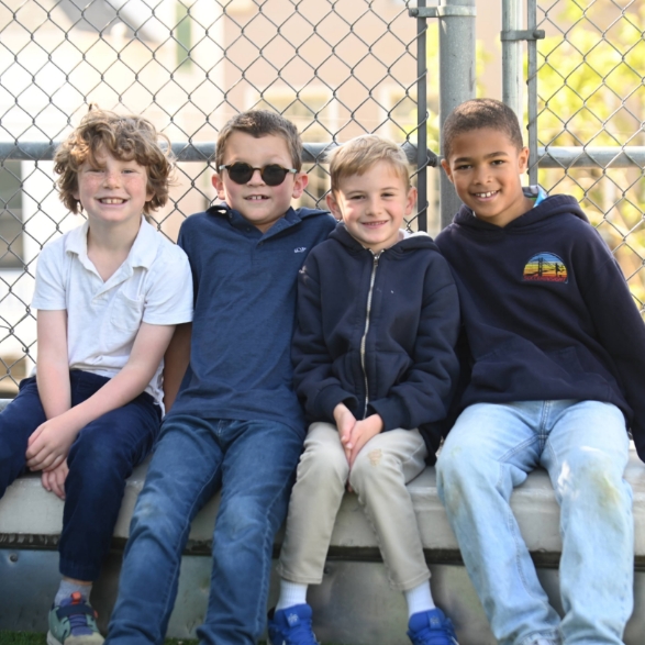 Four students sitting on a bench.