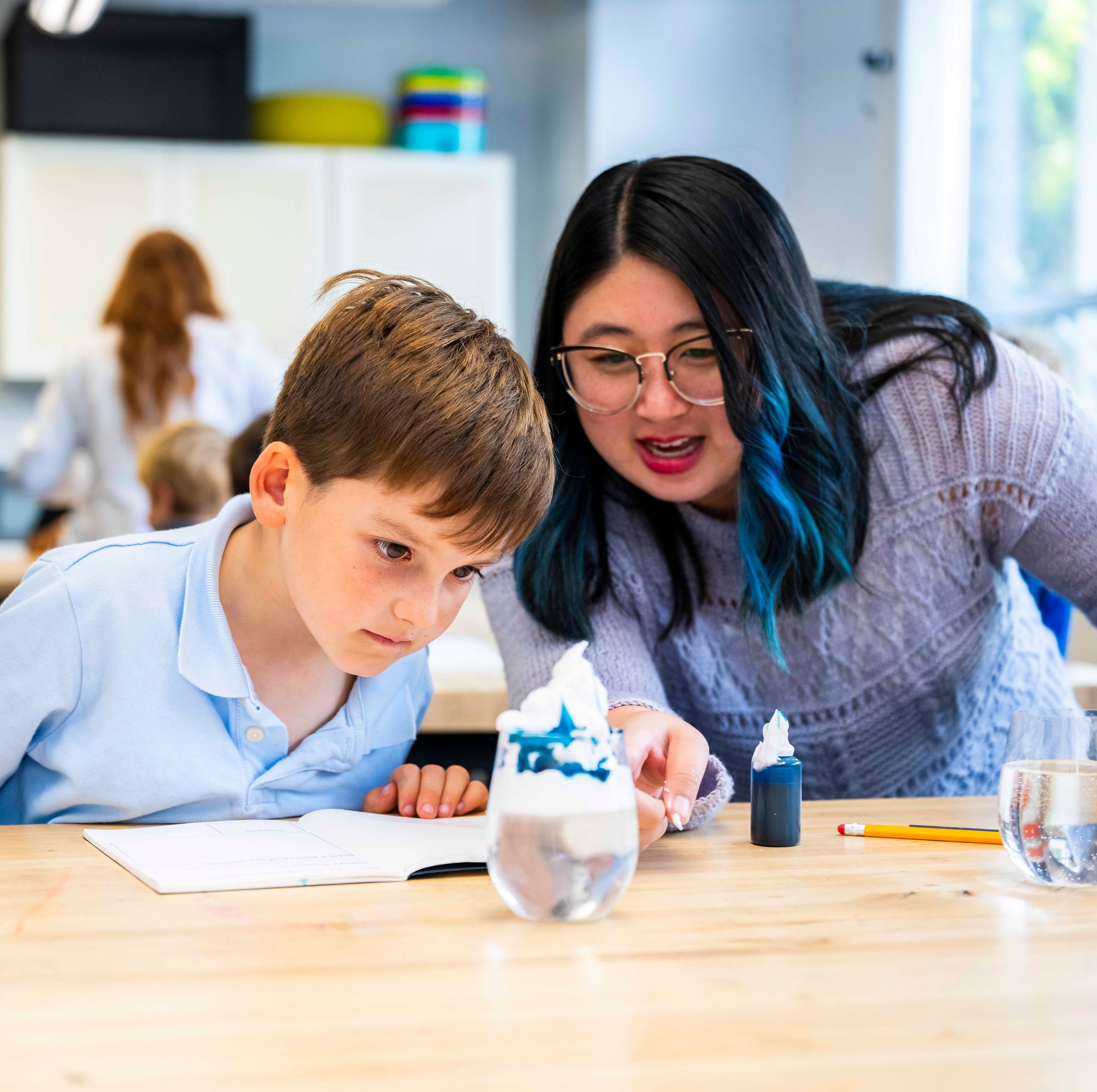 A teacher helping a student in class.