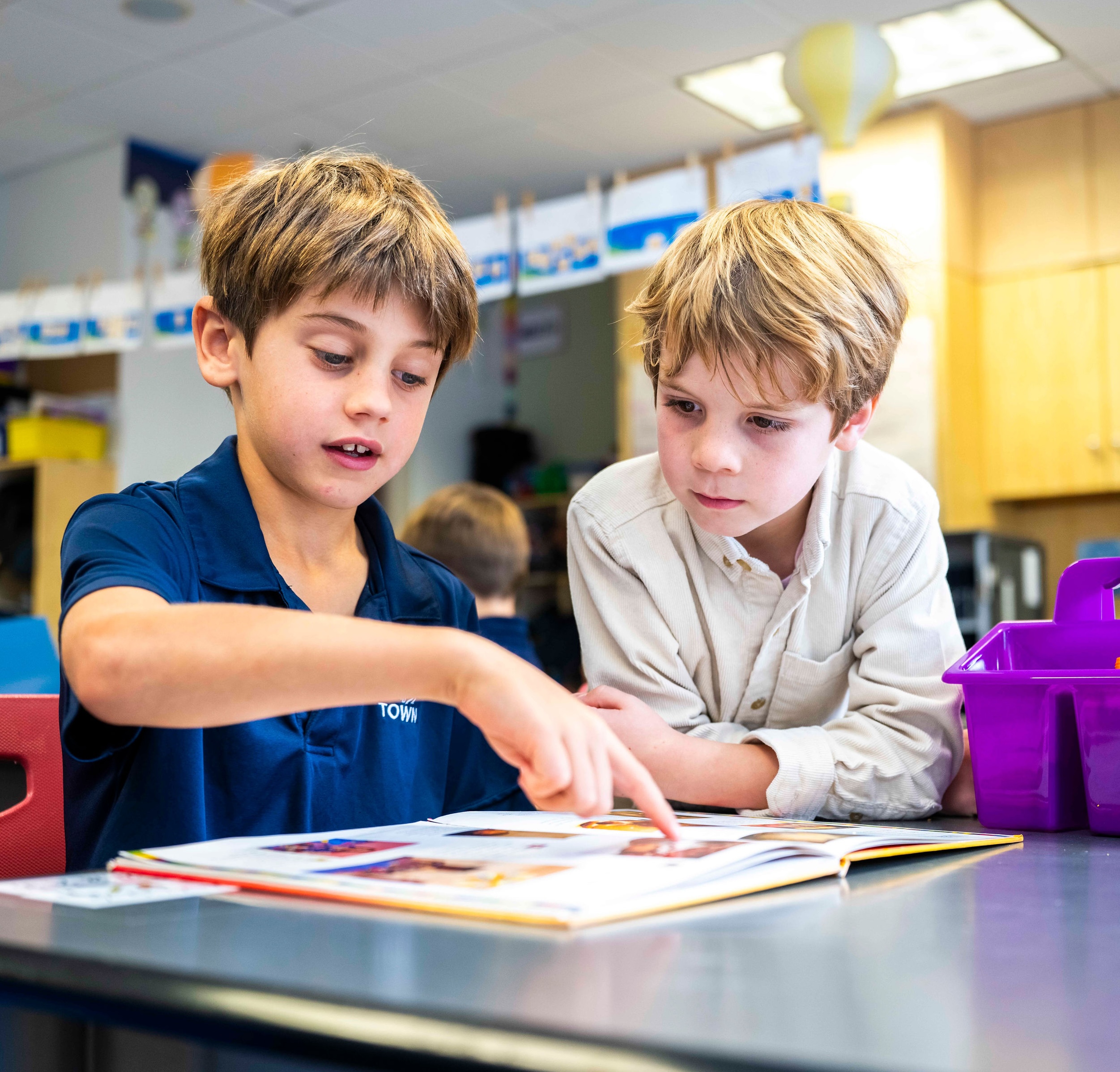 Two students reading a book.