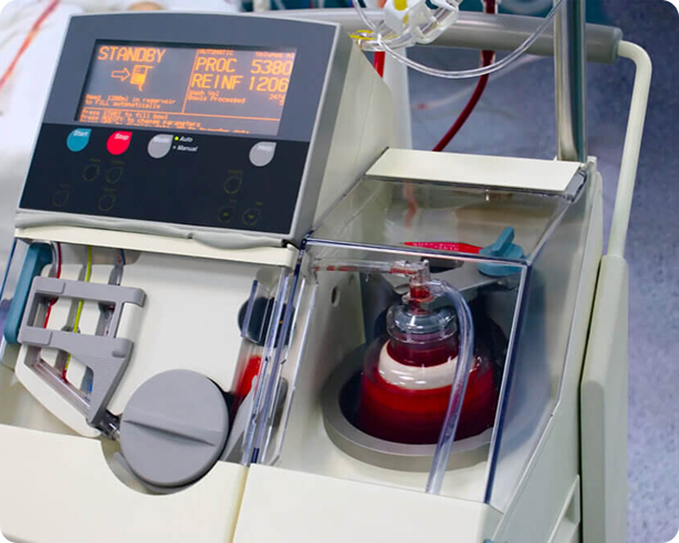 Medical machine with digital display and blood tubing, likely a dialysis or blood processing device.