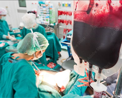 Surgical team in green scrubs performing an operation with a blood transfusion bag in the foreground.