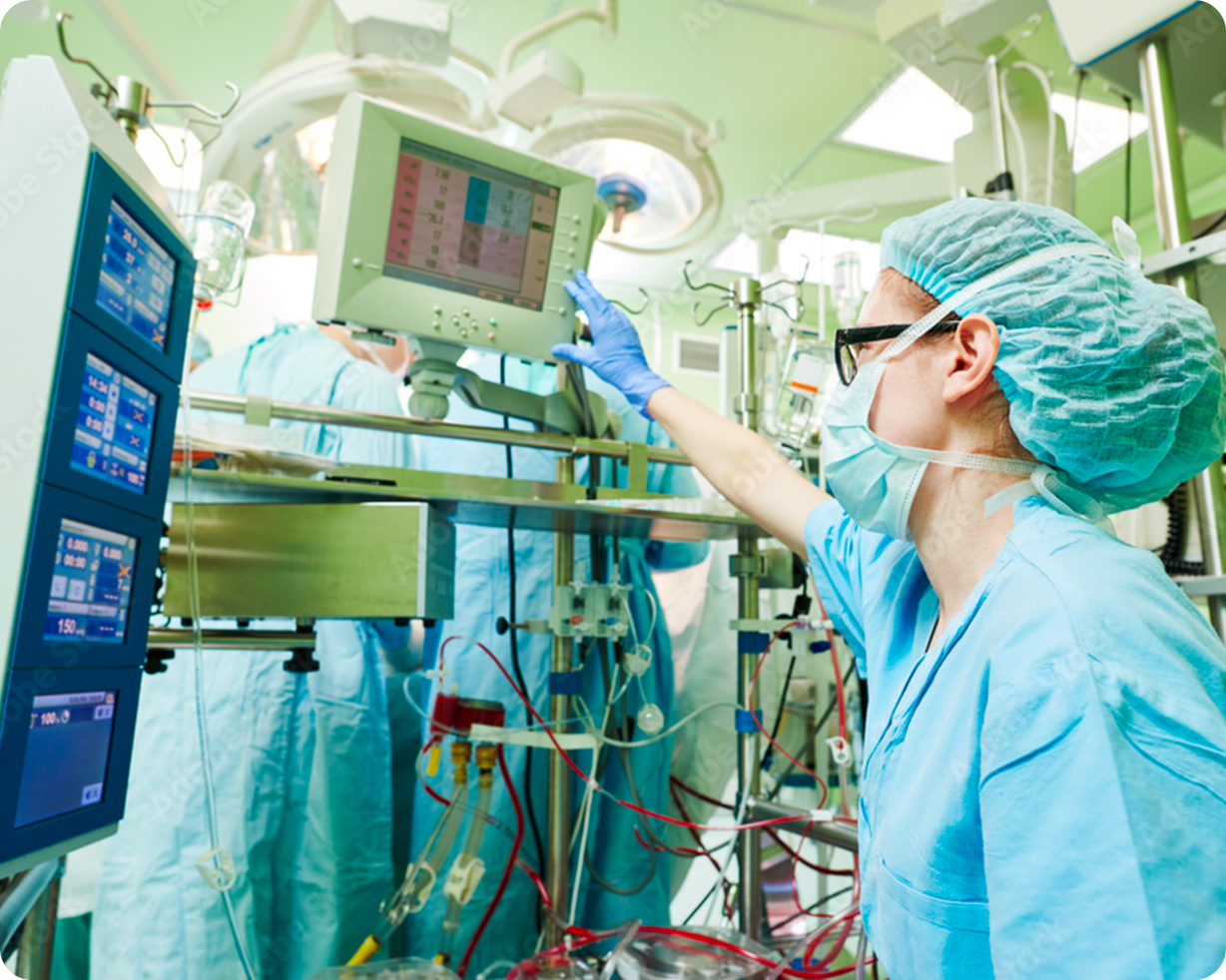 Three surgeons in blue scrubs performing surgery under bright operating room lights.