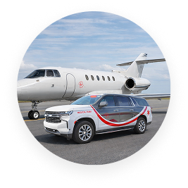 White private jet and white SUV with red and gray graphics parked on airport tarmac.