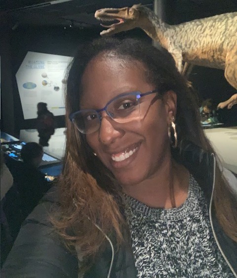 Staff member A. Jackson smiling at a natural history museum