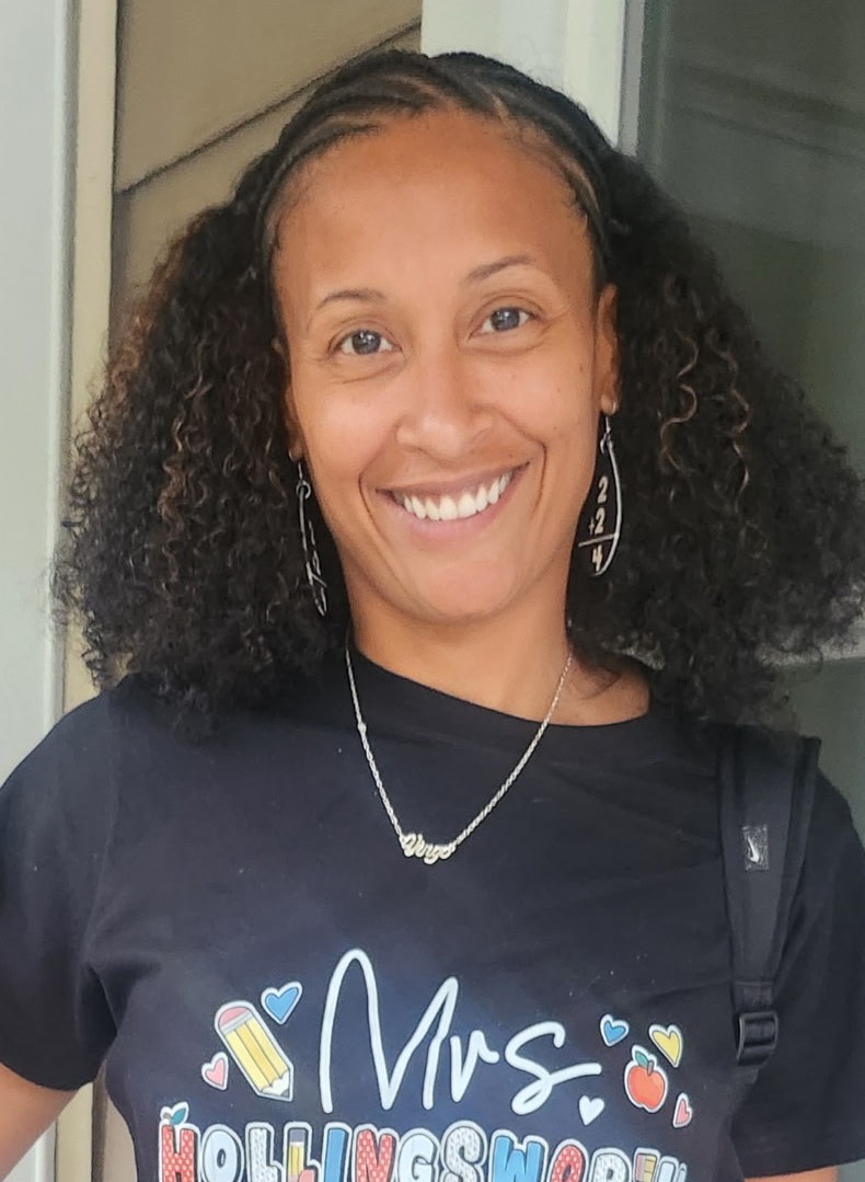 Mrs Hollingsworth smiling in a teacher shirt at school