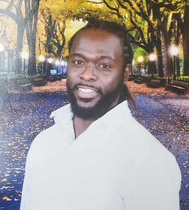 Staff member I. Peterson smiling in autumn park setting