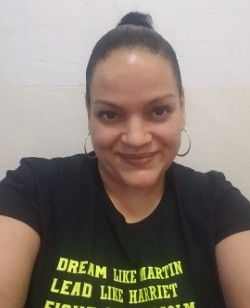 Staff member M. Rivera smiling in a black graphic tee