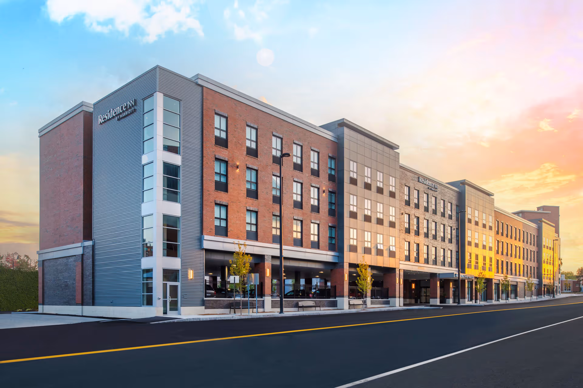 Residence Inn by Marriott multi-story hotel building under a colorful sunset sky.