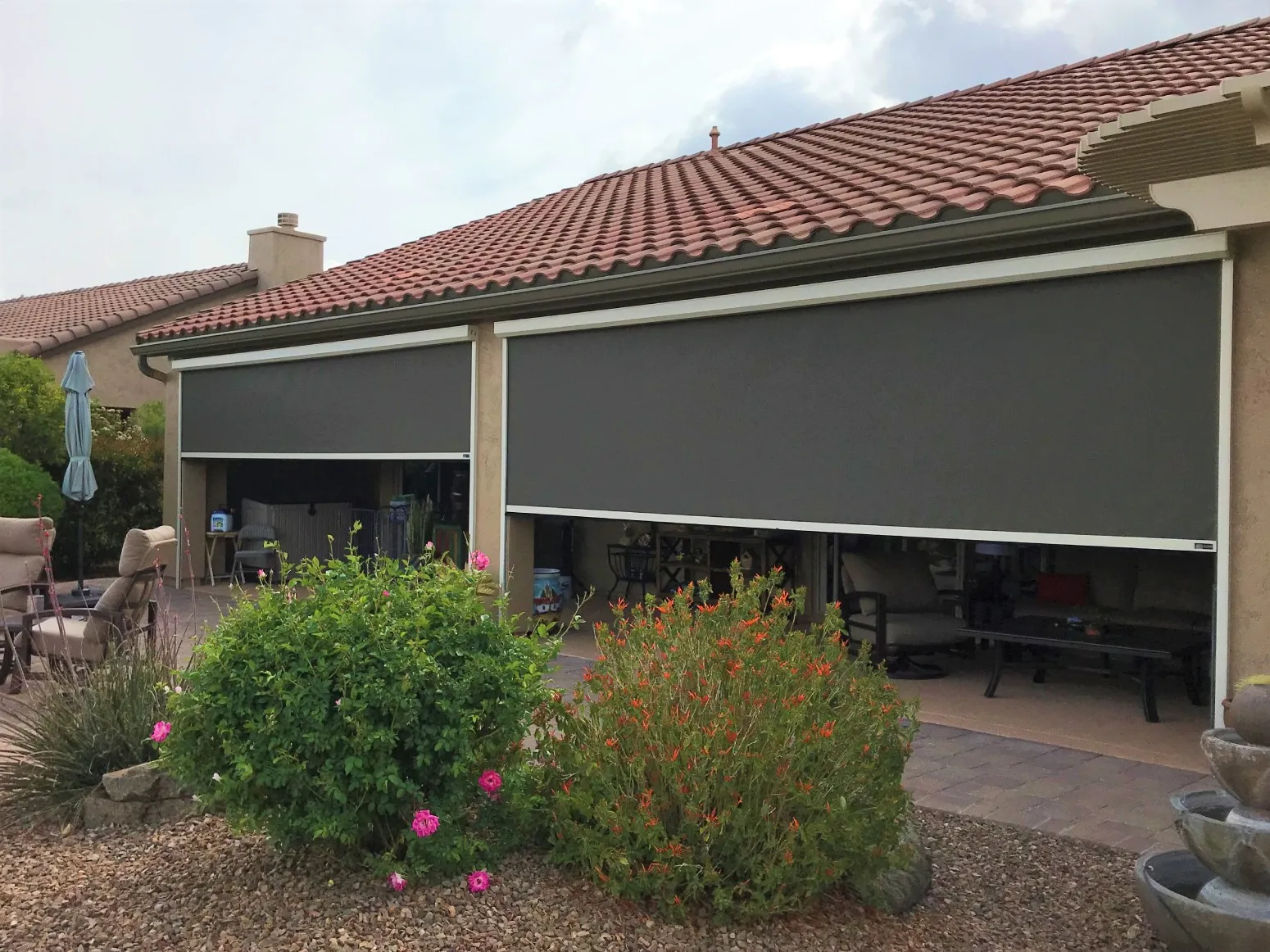 Solar screens partially deployed in a backyard