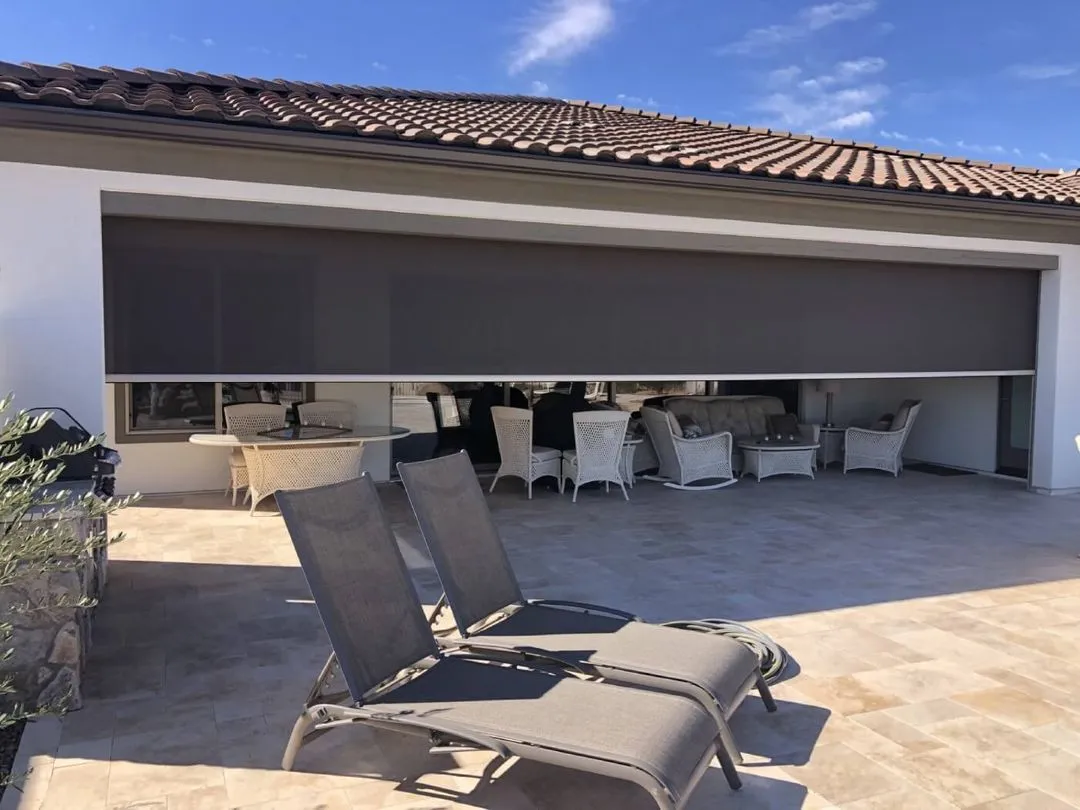 Patio with rolling screen shade and lounge chairs.