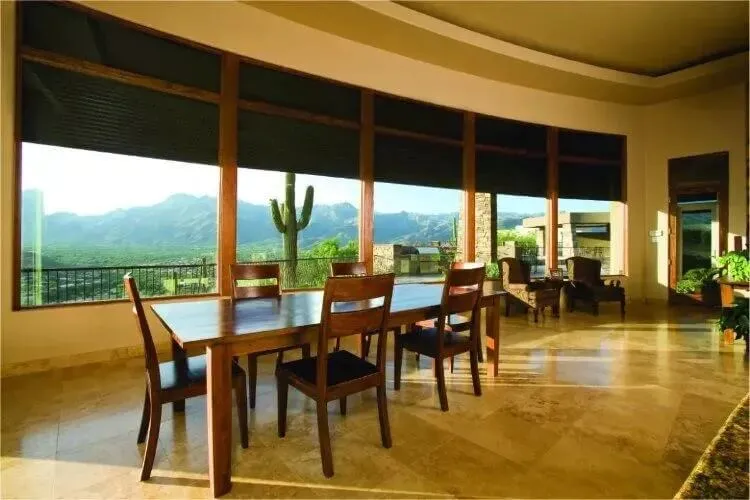 Spacious dining room with large windows showcasing a desert landscape.