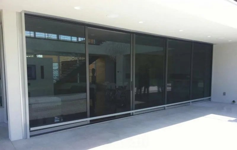 Large sliding glass doors with dark rolling shutters.