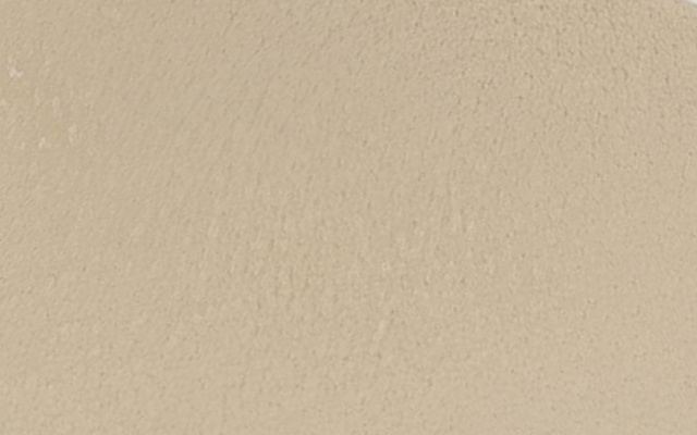 A textured surface painted in a light beige color.